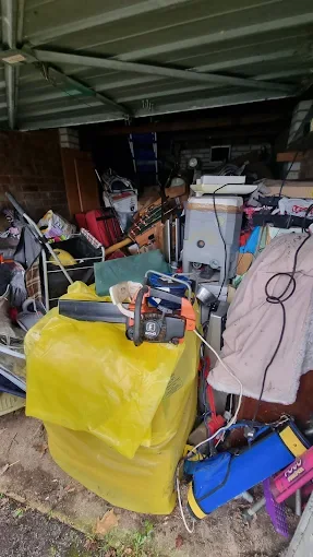 Garage packed with furniture, tools and bagged items before clearance